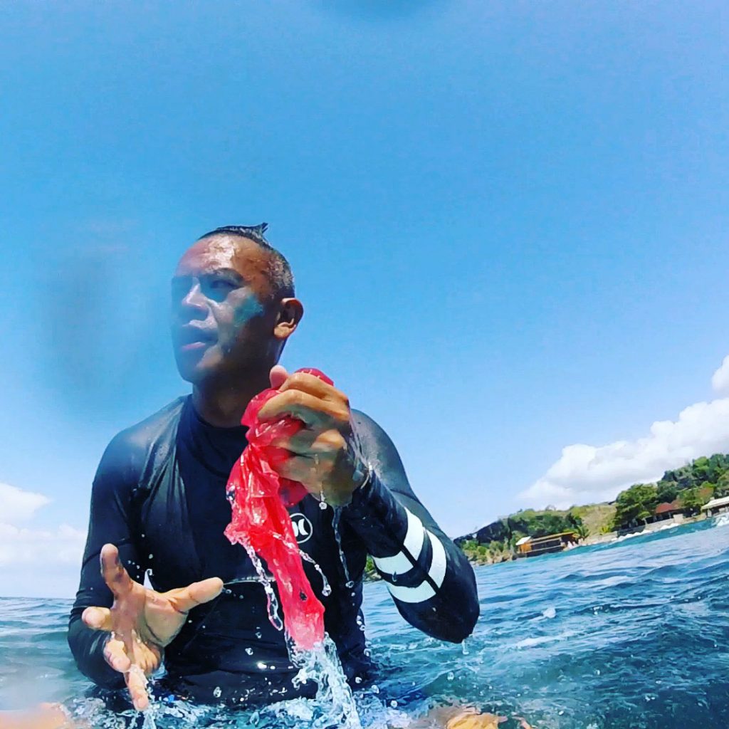 man catches plastic whilst surfing